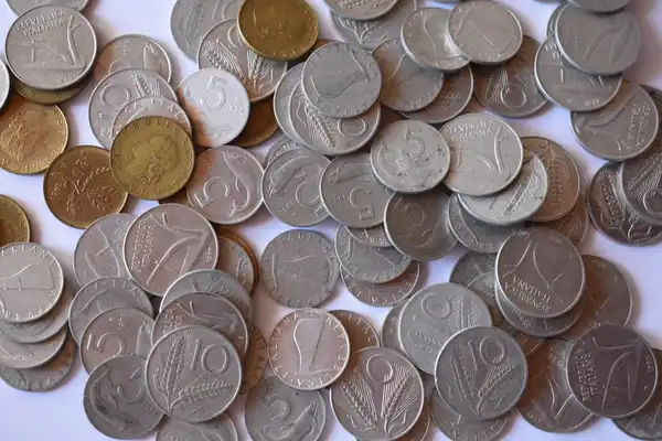 A pile of old silver and brass coins of different sizes, seen from above.